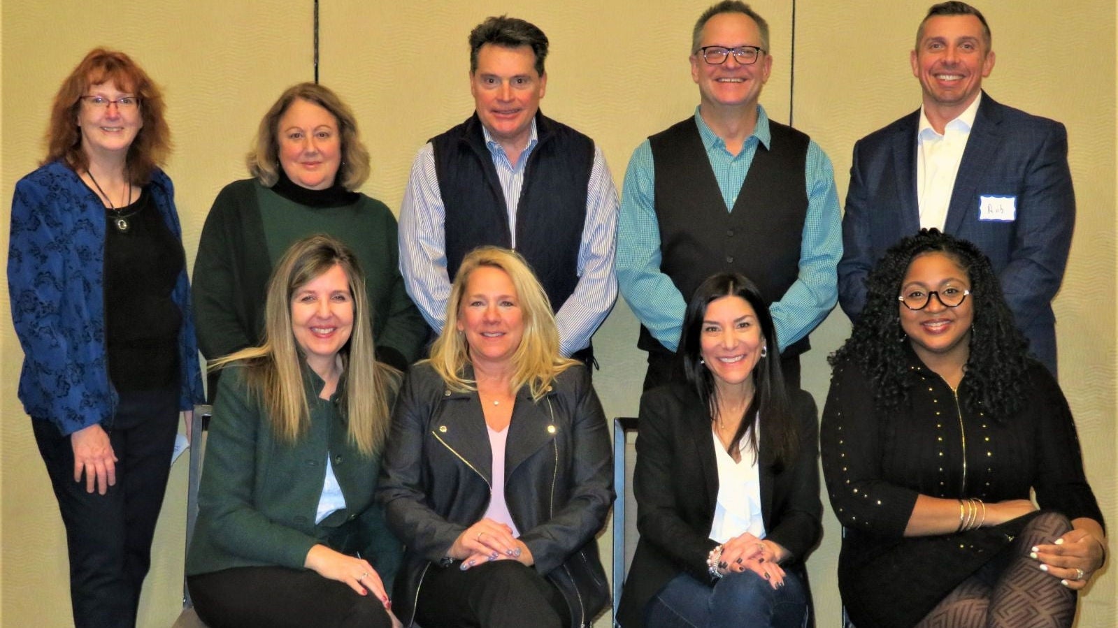 Photo of nine individuals on the board